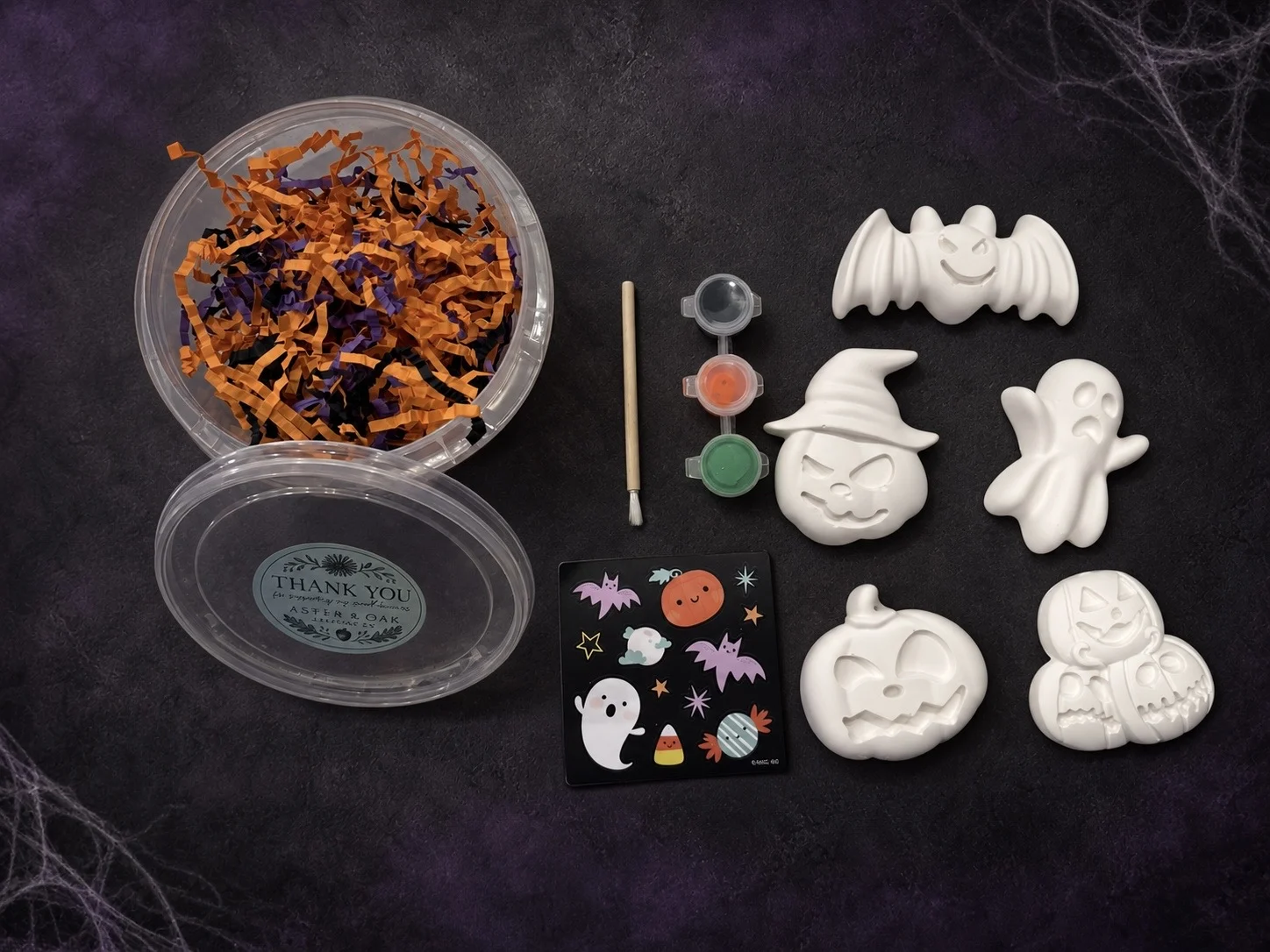 Boo Bucket contents including five plaster figures, paints, brush, and sticker sheet