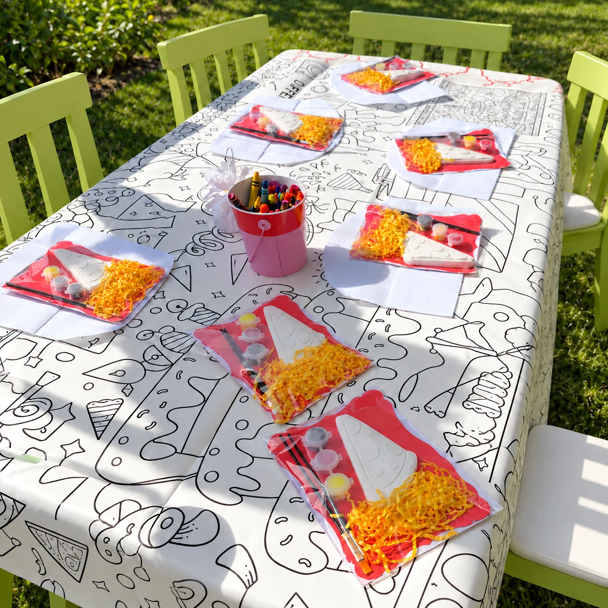 Pizza-themed paint-your-own party favors arranged around an outdoor activity table